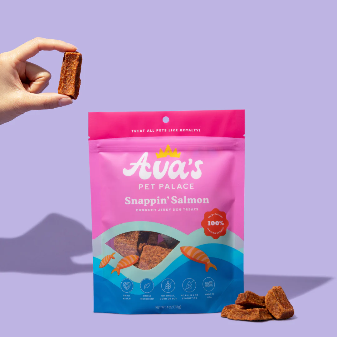 American Pet Supplies salmon jerky dog treats in pink blue packaging with a hand holding one treat