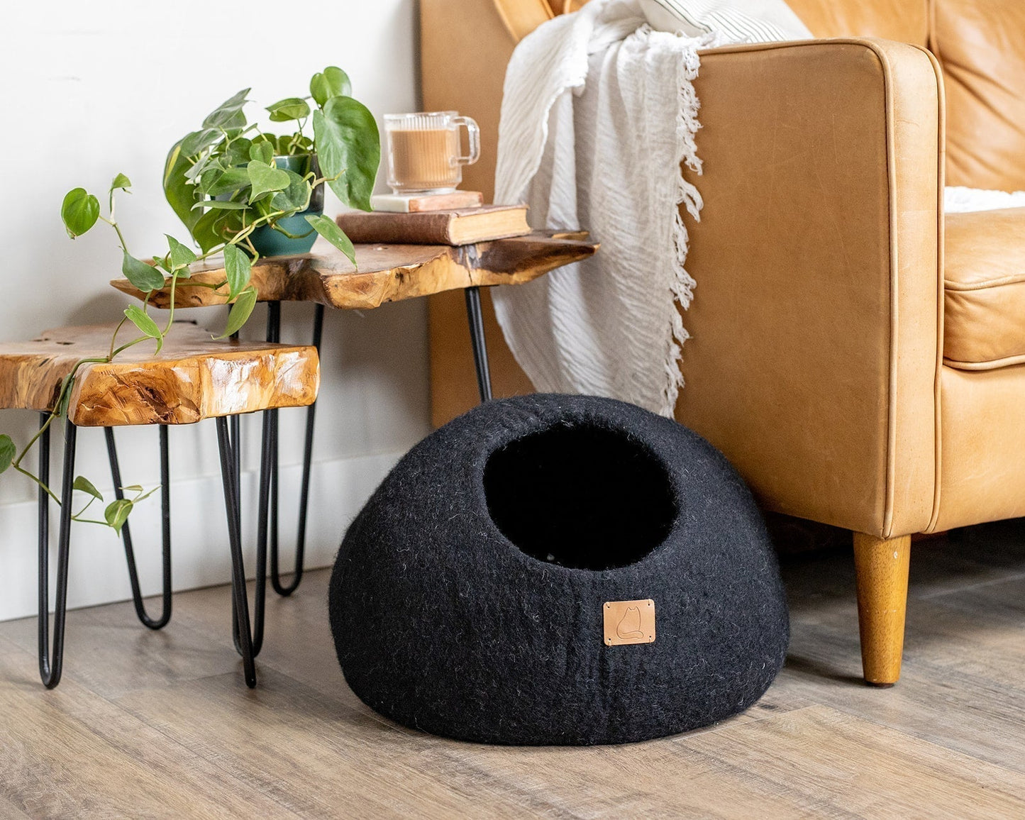 The Family Pet black pet cave bed placed on floor near leather couch and wooden side tables