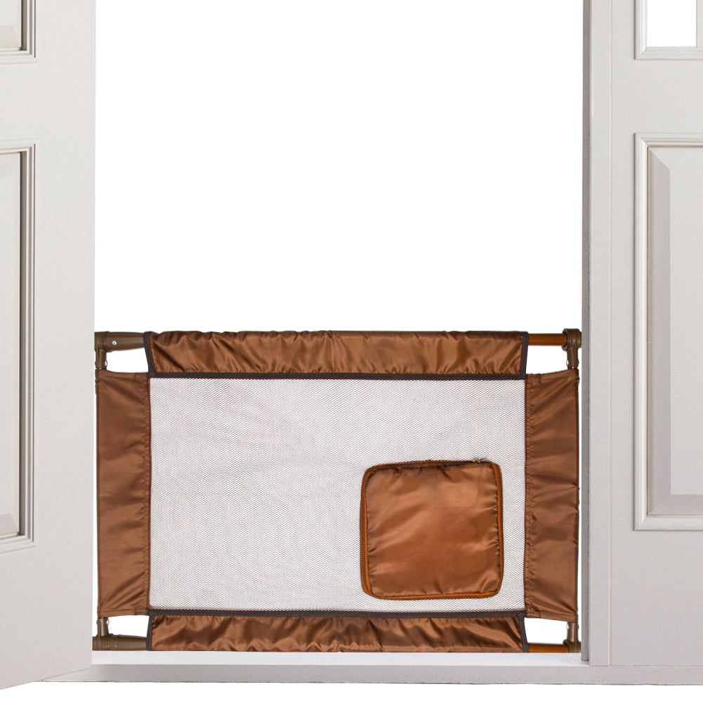 Brown collapsible pet gate for travel installed in doorway with mesh center and fabric edges