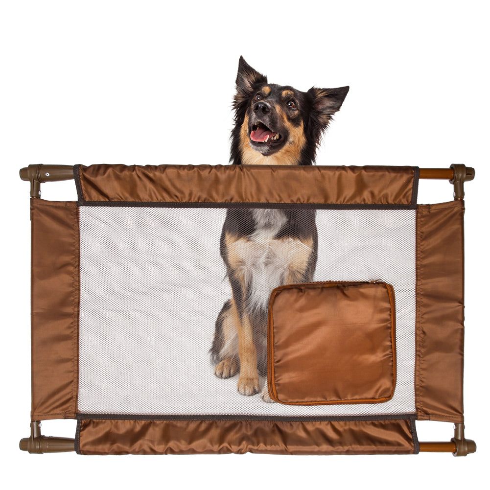 Collapsible pet gate for travel in brown with mesh center and small dog sitting behind it