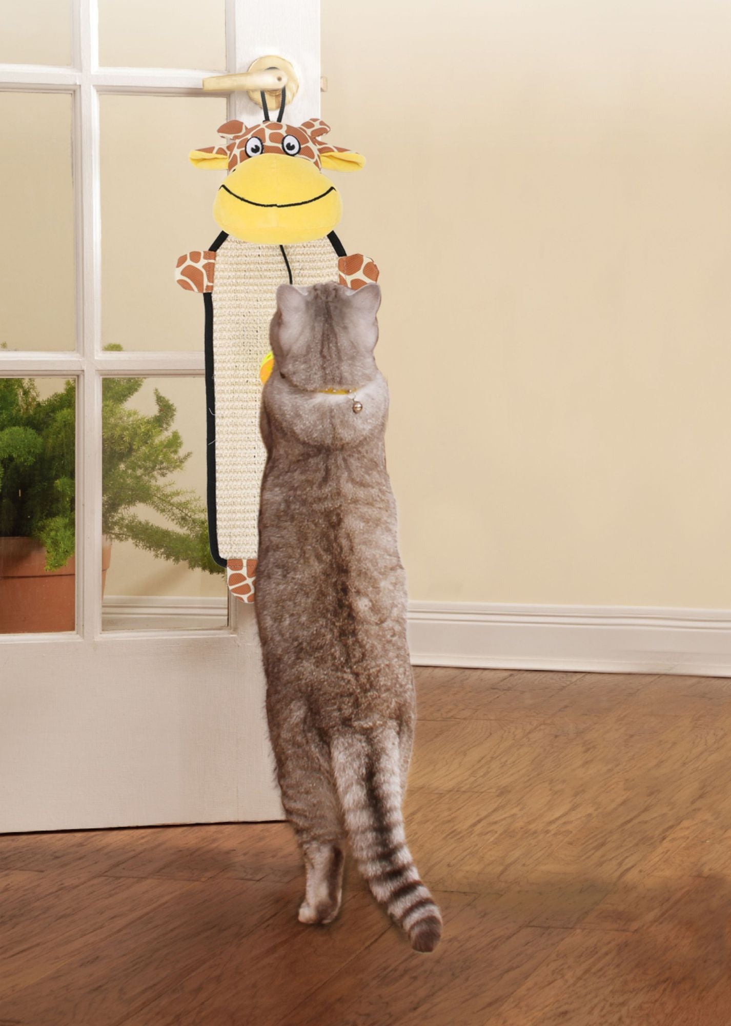 Cat scratching the eco-friendly cat scratcher with a giraffe design hanging on a door