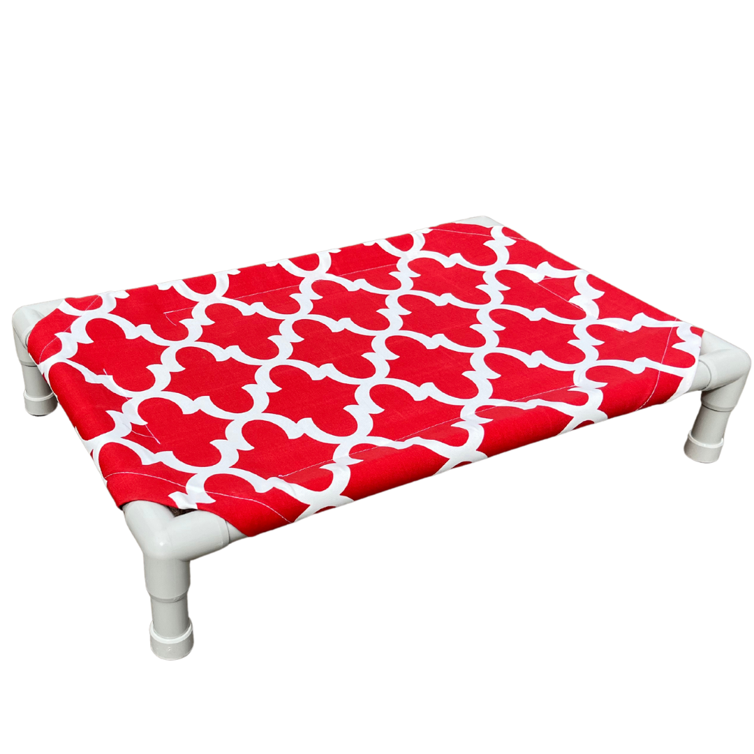 The Family Pet elevated pet bed with white frame and red patterned fabric for pet comfort