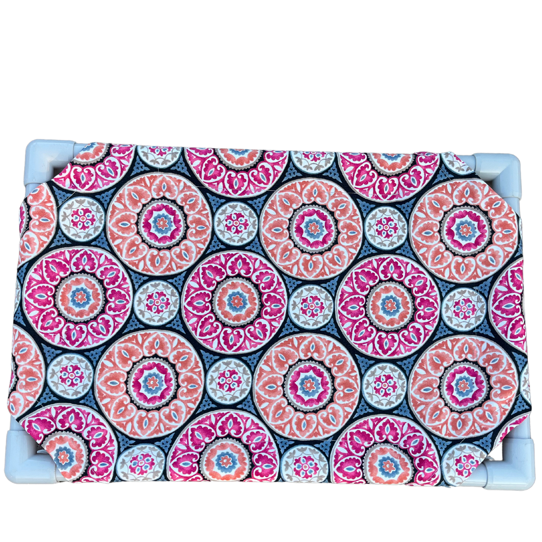 The Family Pet elevated pet bed with colorful circular patterned fabric and sturdy blue frame
