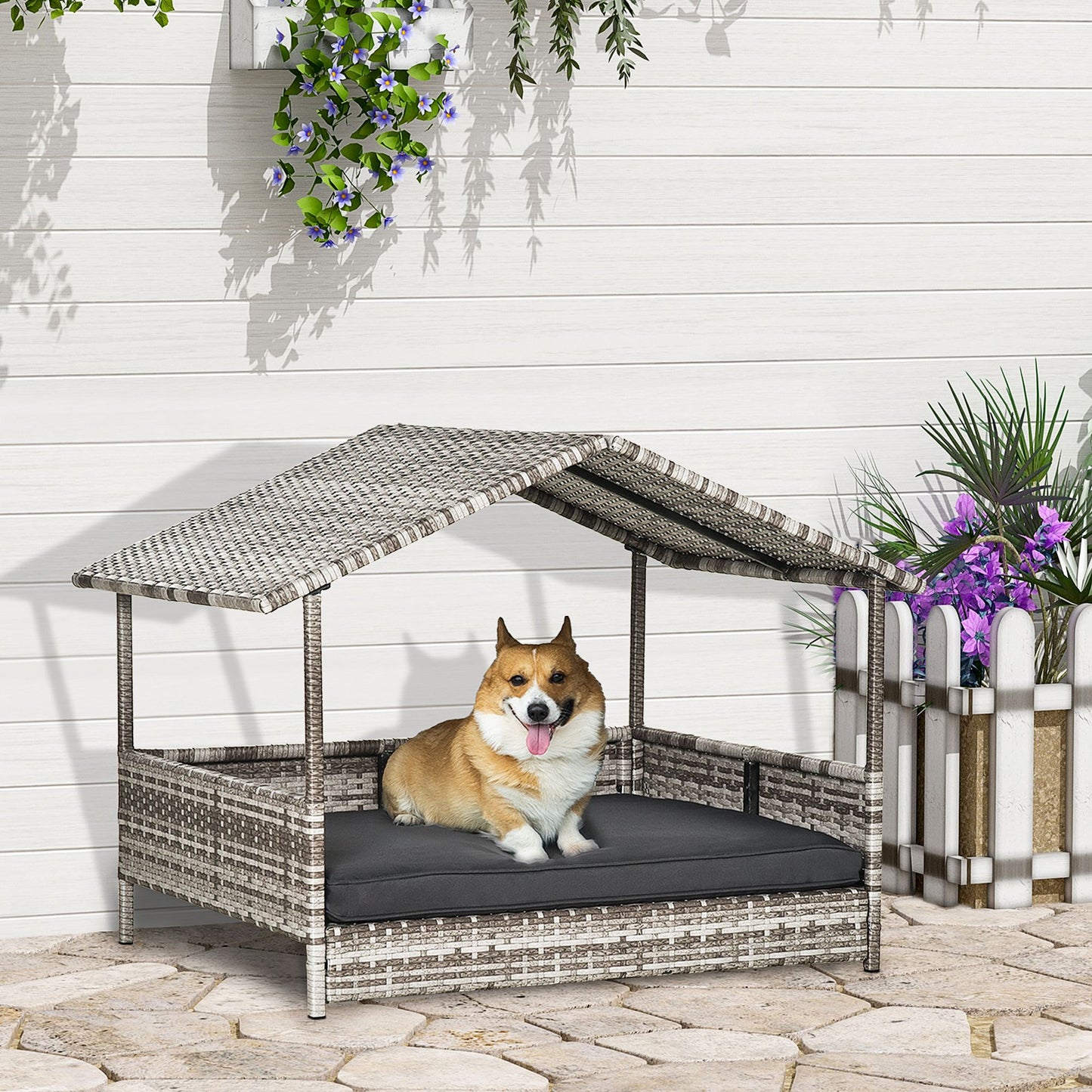 Elevated wicker dog house with roof and black cushion featuring a happy corgi sitting inside