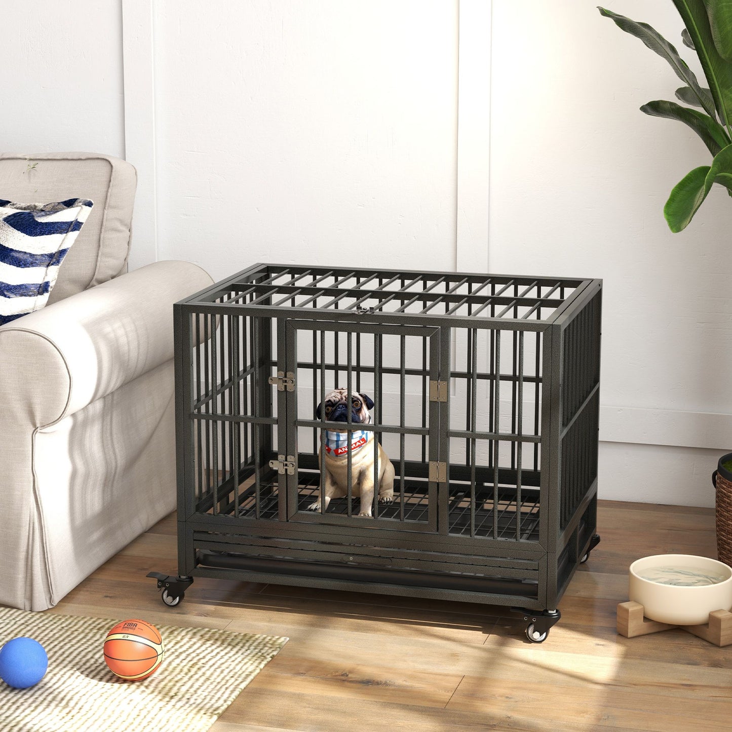 Heavy duty dog crate with a small dog inside placed next to a sofa in a living room