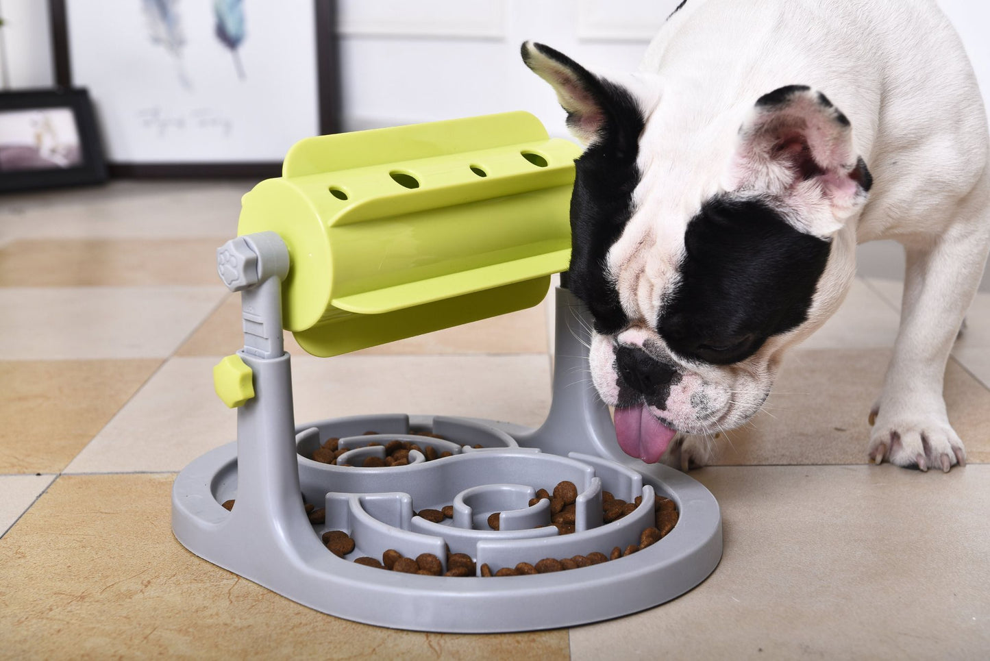 Dog using an interactive dog puzzle feeder with rotating green and gray sections on a tiled floor