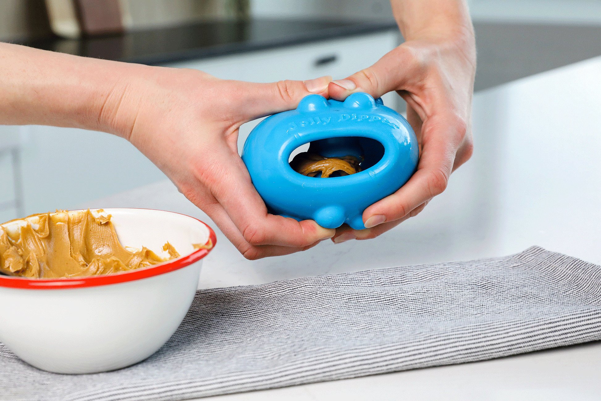 Jolly Dipper dog toy being filled with peanut butter for dogs to enjoy and engage with