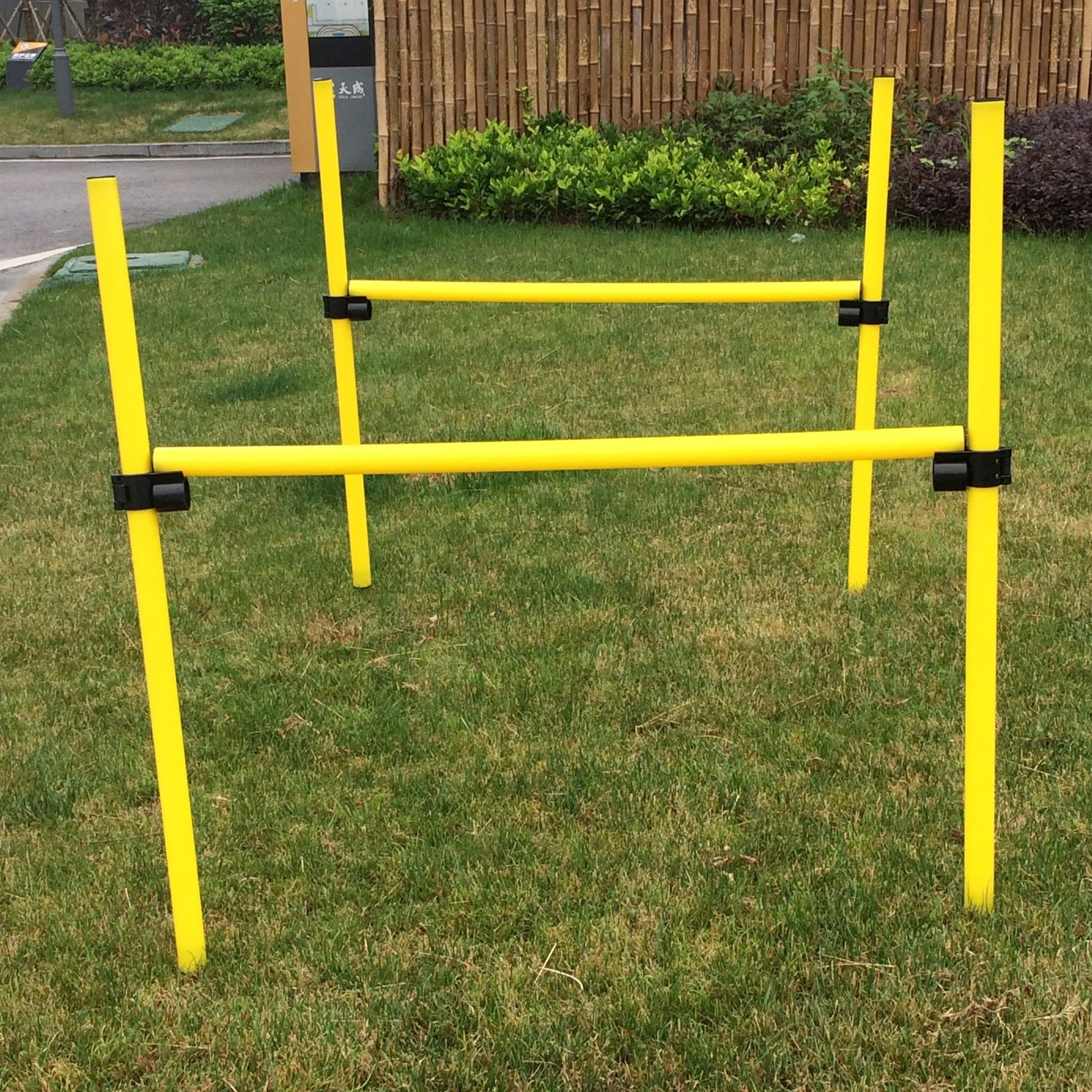 Yellow pet life jumping hurdle on green grass for pet agility training outdoors