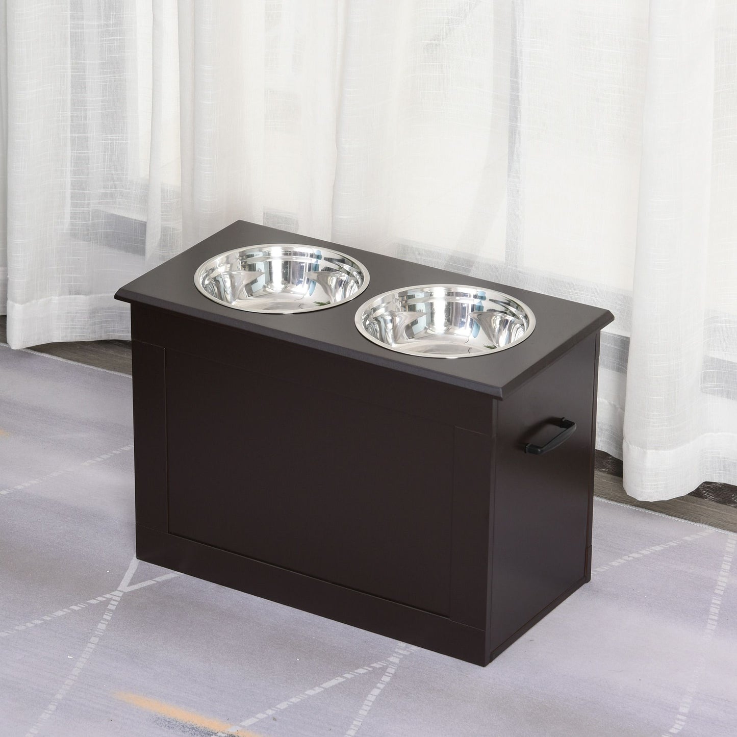 Black raised dog feeding station with two stainless steel bowls on a gray rug near white curtains