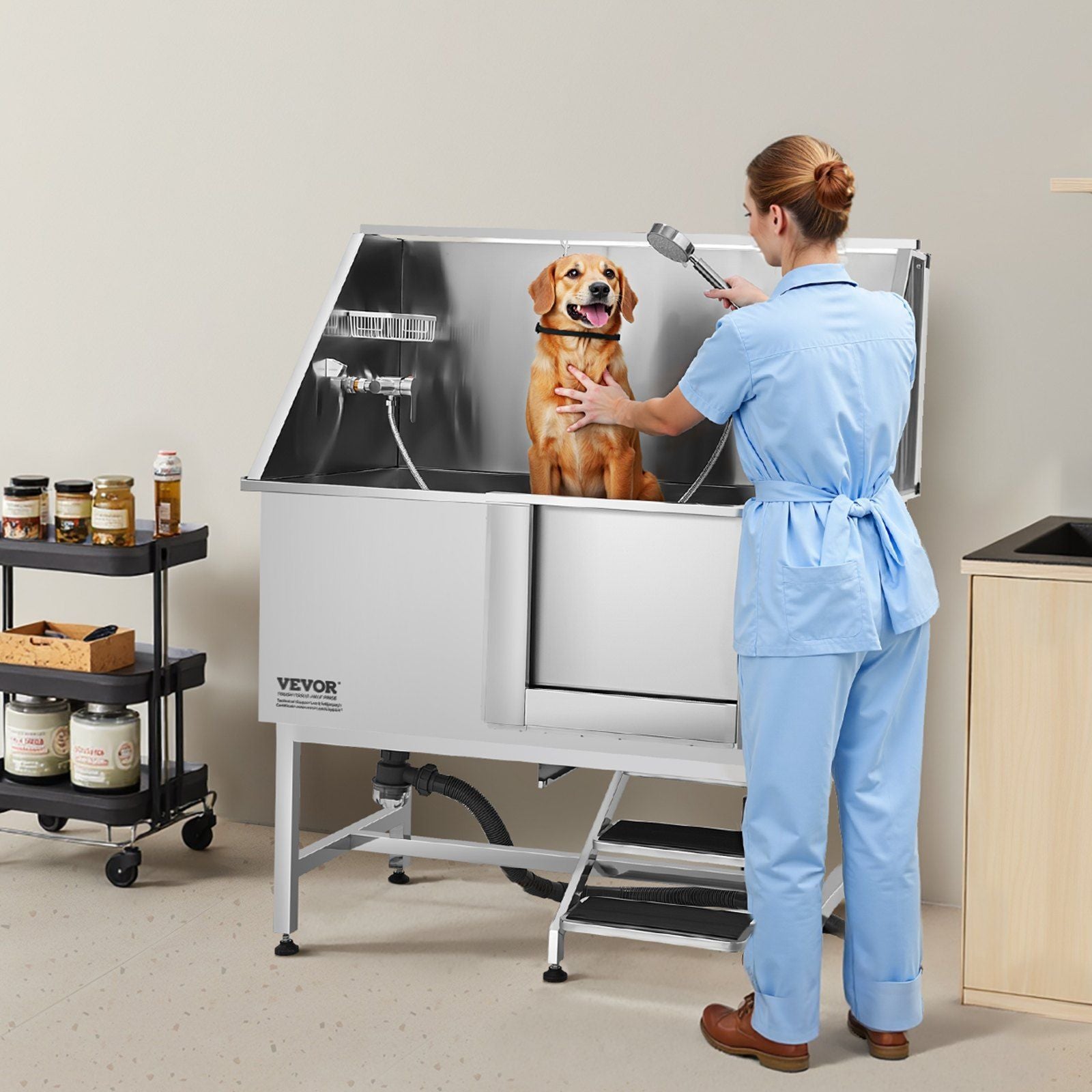 Stainless steel dog grooming tub in a clean salon setting with a groomer washing a dog