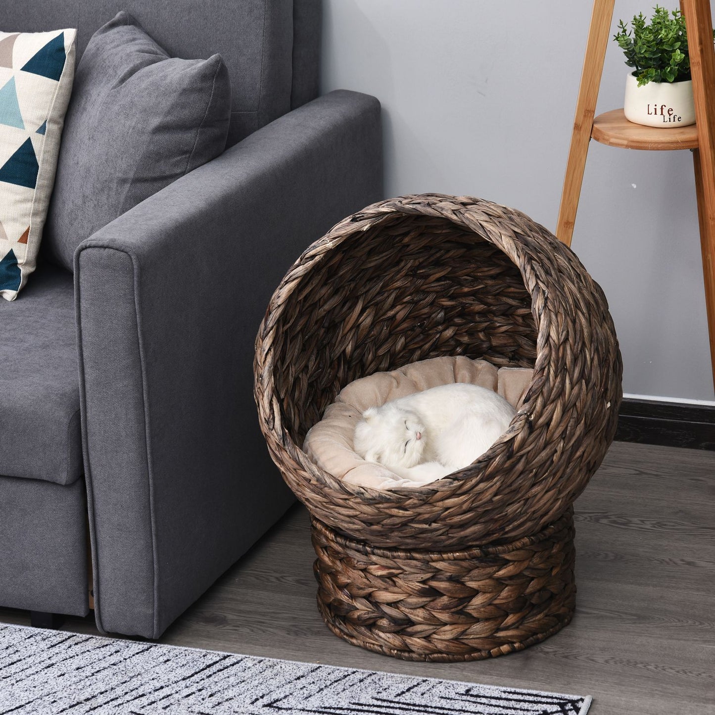 Wicker cat bed with cushion featuring a cozy round design with a sleeping white cat inside