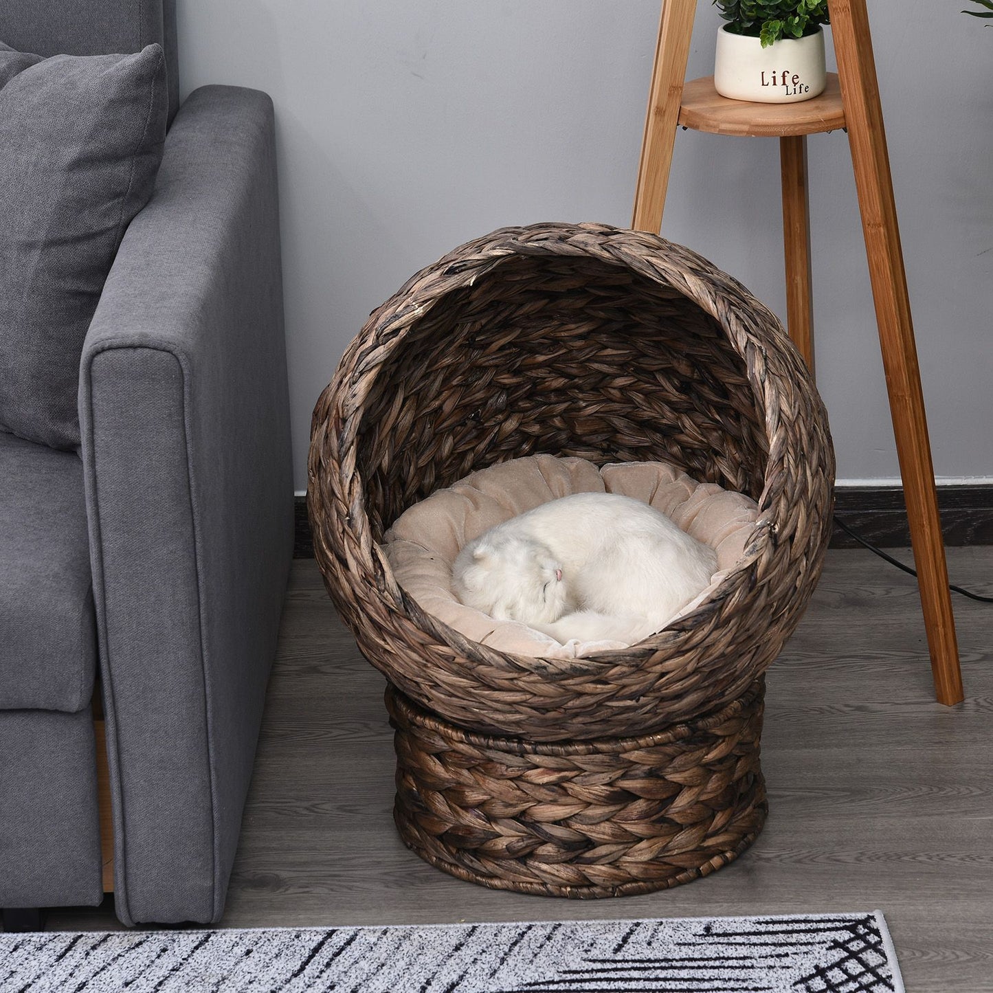 Wicker cat bed with cushion featuring a cozy dome design with a sleeping white cat inside