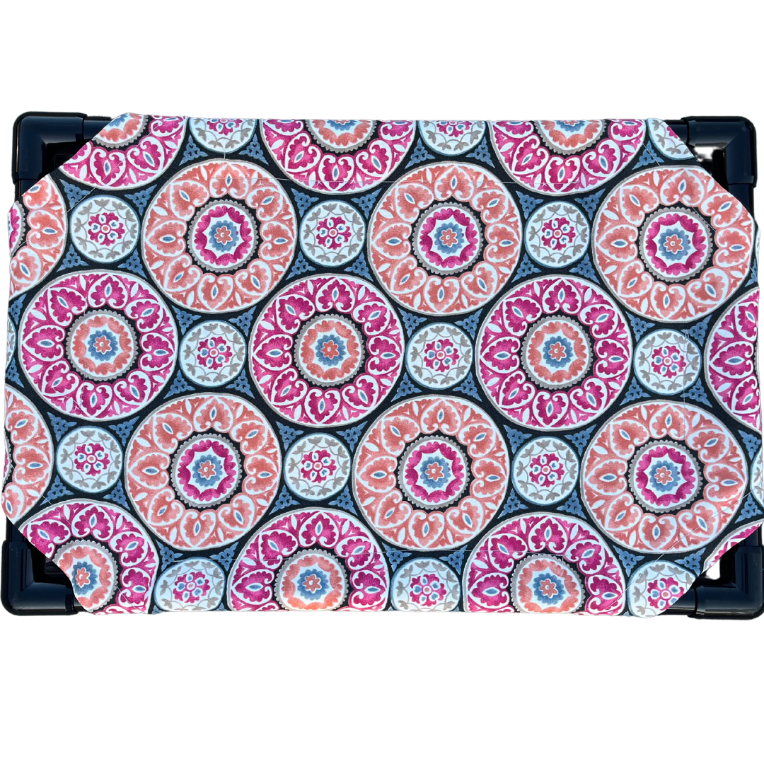 The Family Pet elevated pet bed with colorful circular patterned fabric and sturdy black frame