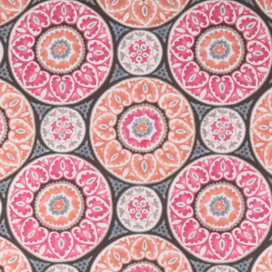 Colorful patterned fabric for elevated pet bed with pink and orange circular floral designs