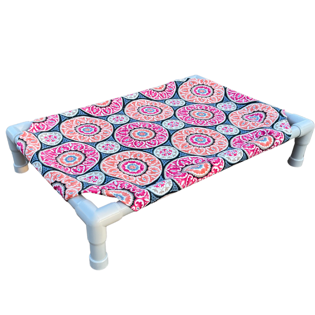 The Family Pet elevated pet bed with colorful patterned fabric and sturdy white PVC frame