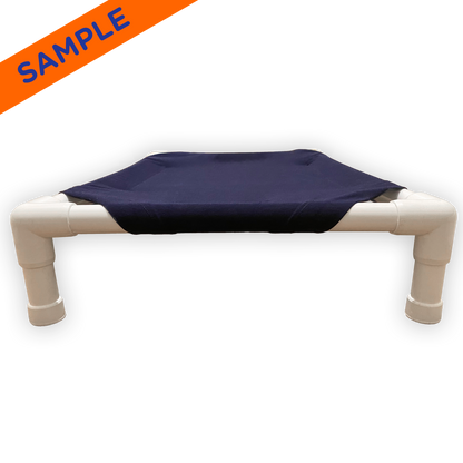 The Family Pet elevated pet bed with sturdy white frame and navy blue fabric platform