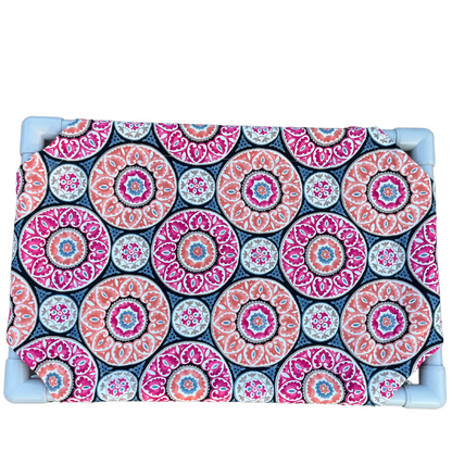 The Family Pet elevated pet bed with colorful circular patterned fabric and sturdy blue frame