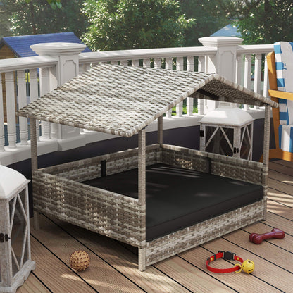 Elevated wicker dog house with canopy roof and cushioned bed placed on outdoor wooden deck