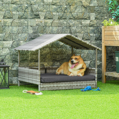 Elevated wicker dog house with a roof and cushion featuring a happy dog lying on green lawn