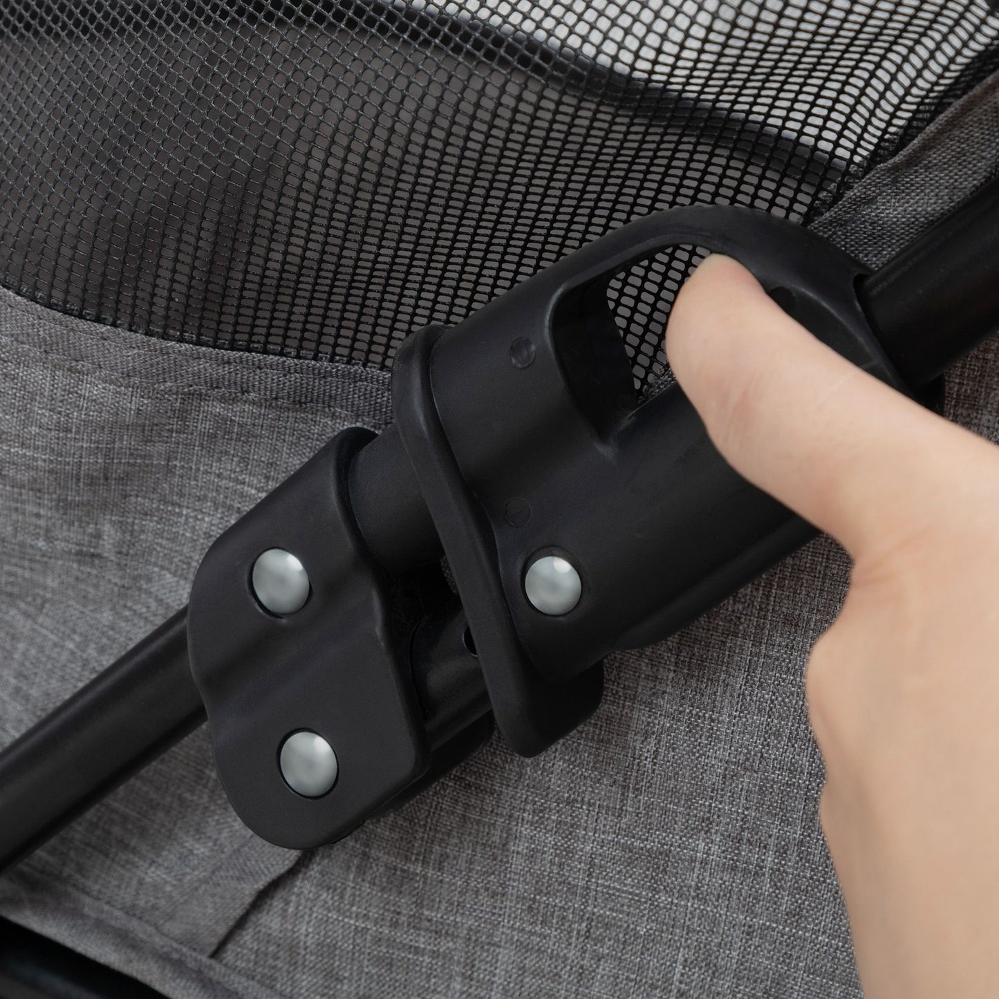Close-up of a hand engaging the folding mechanism on a foldable pet stroller from PawCounter.com