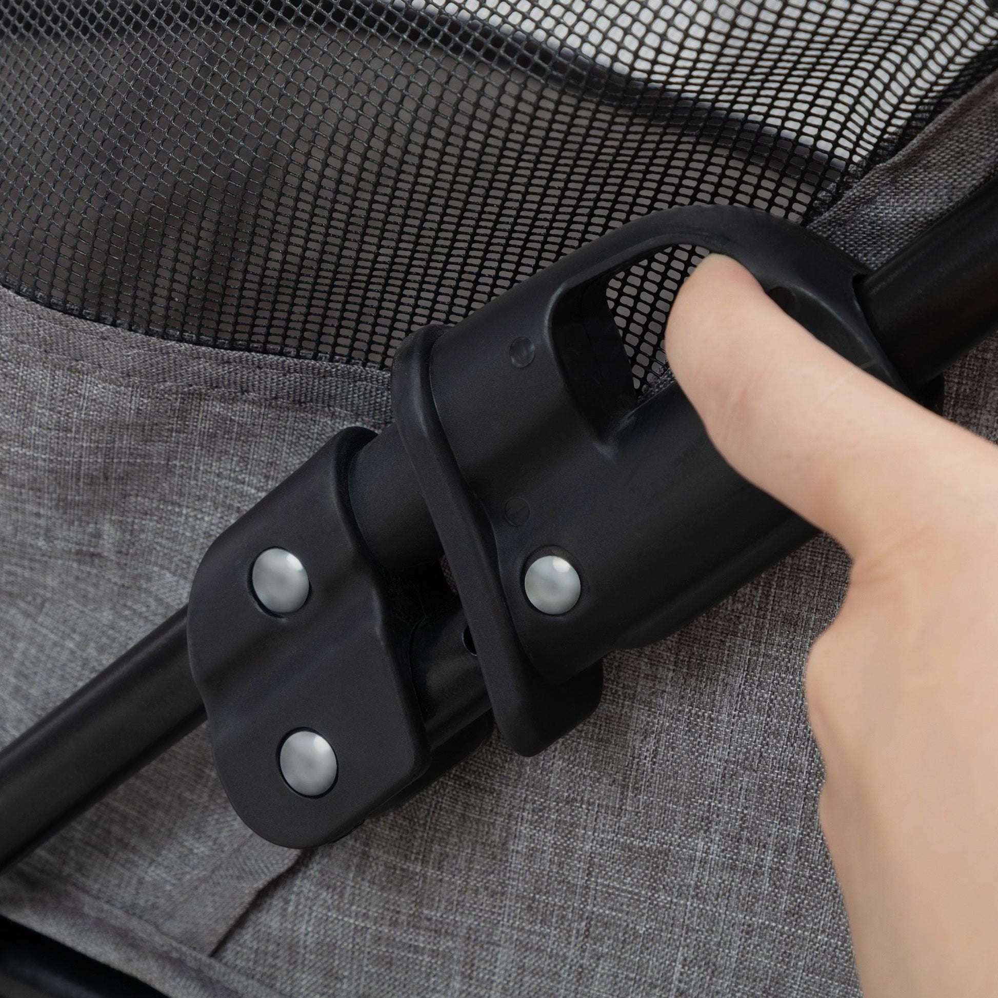 Close-up of a hand engaging the folding mechanism on a foldable pet stroller from PawCounter.com