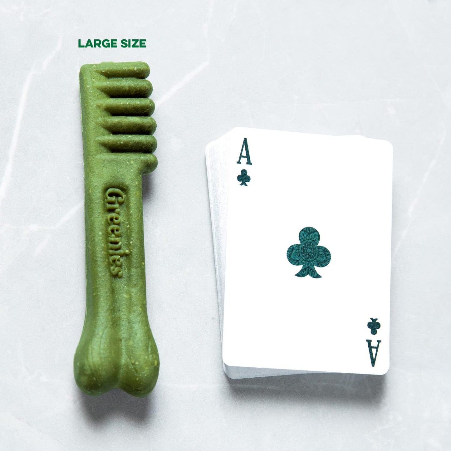Greenies dental treats for large dogs next to a playing card for size reference