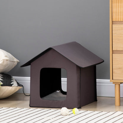 Cozy heated cat house for outdoor use with an open entrance and dark exterior design