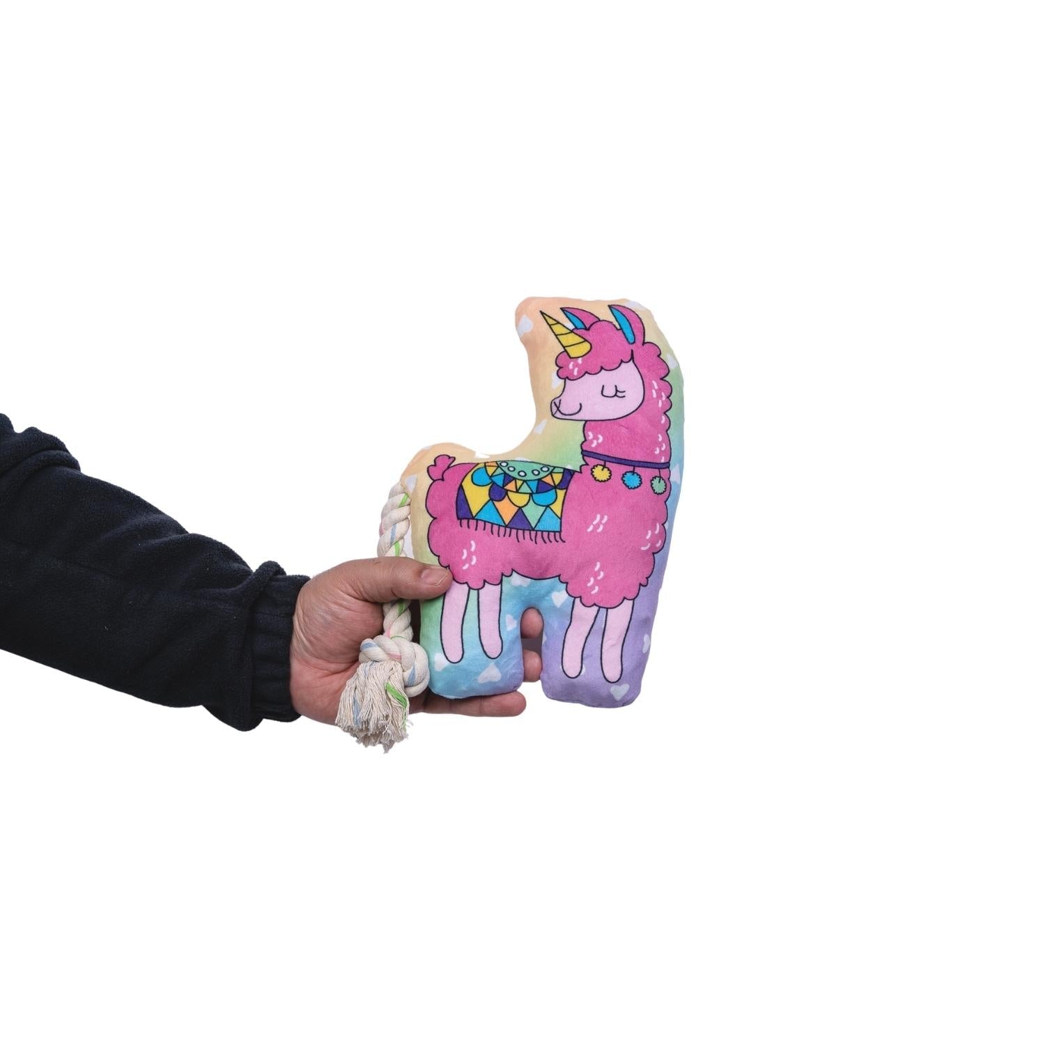 Person holding a colorful llama plush dog toy with a rope tail for pets to chew and play