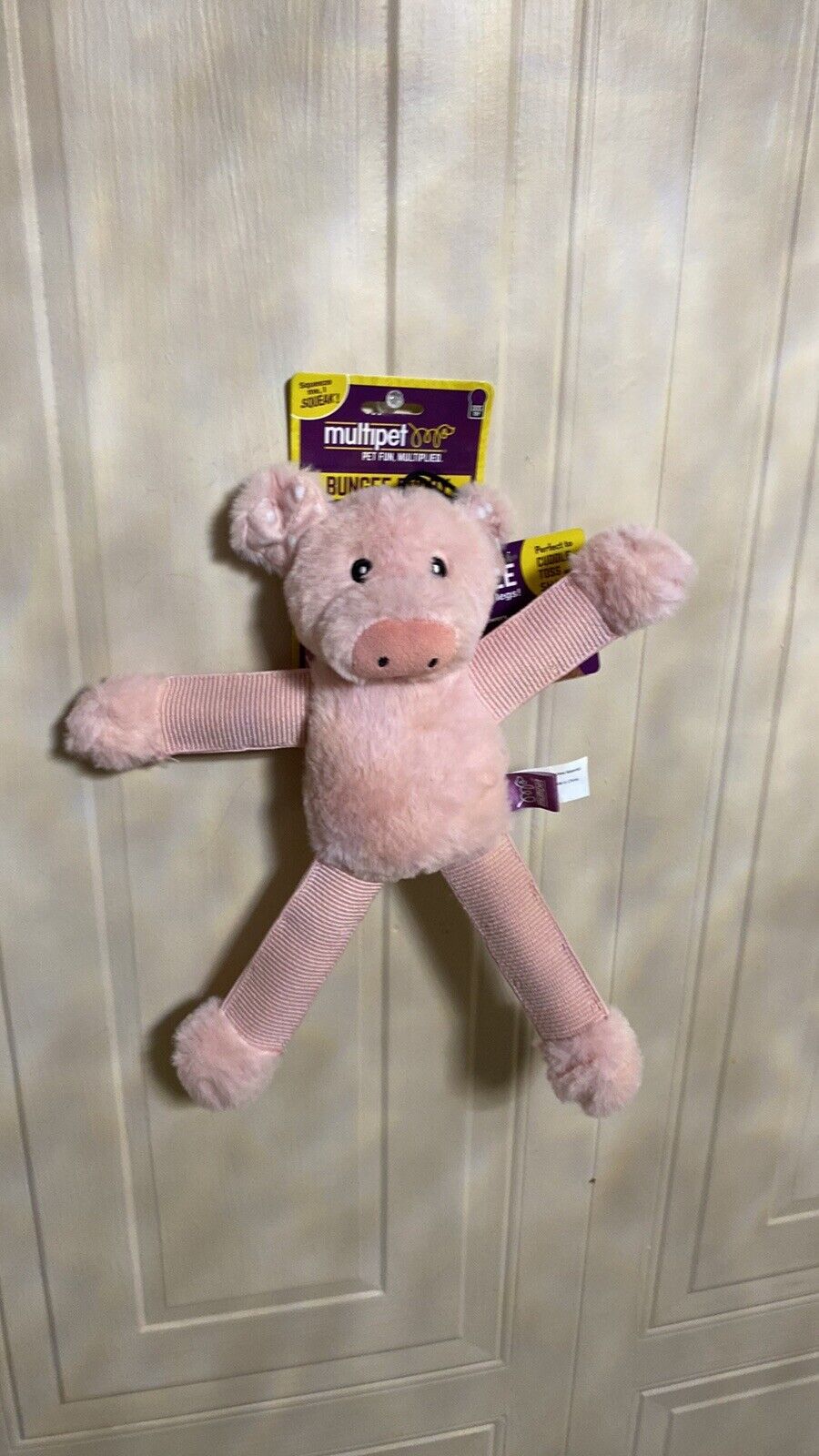 The Family Pet plush dog toy bungee shaped like a pink pig with soft body and textured limbs