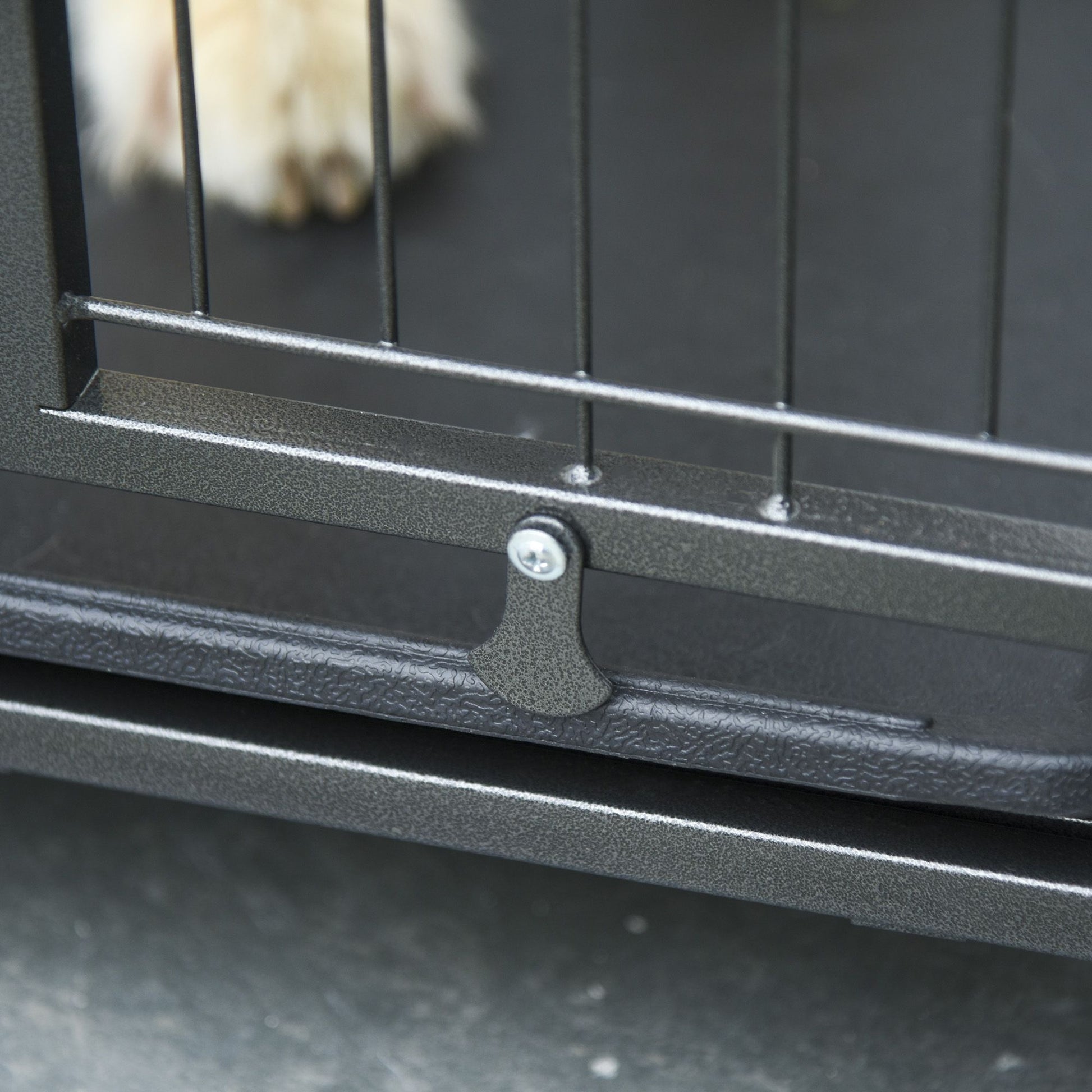 Close-up of latch on heavy duty dog crate with wheels showing durable metal construction