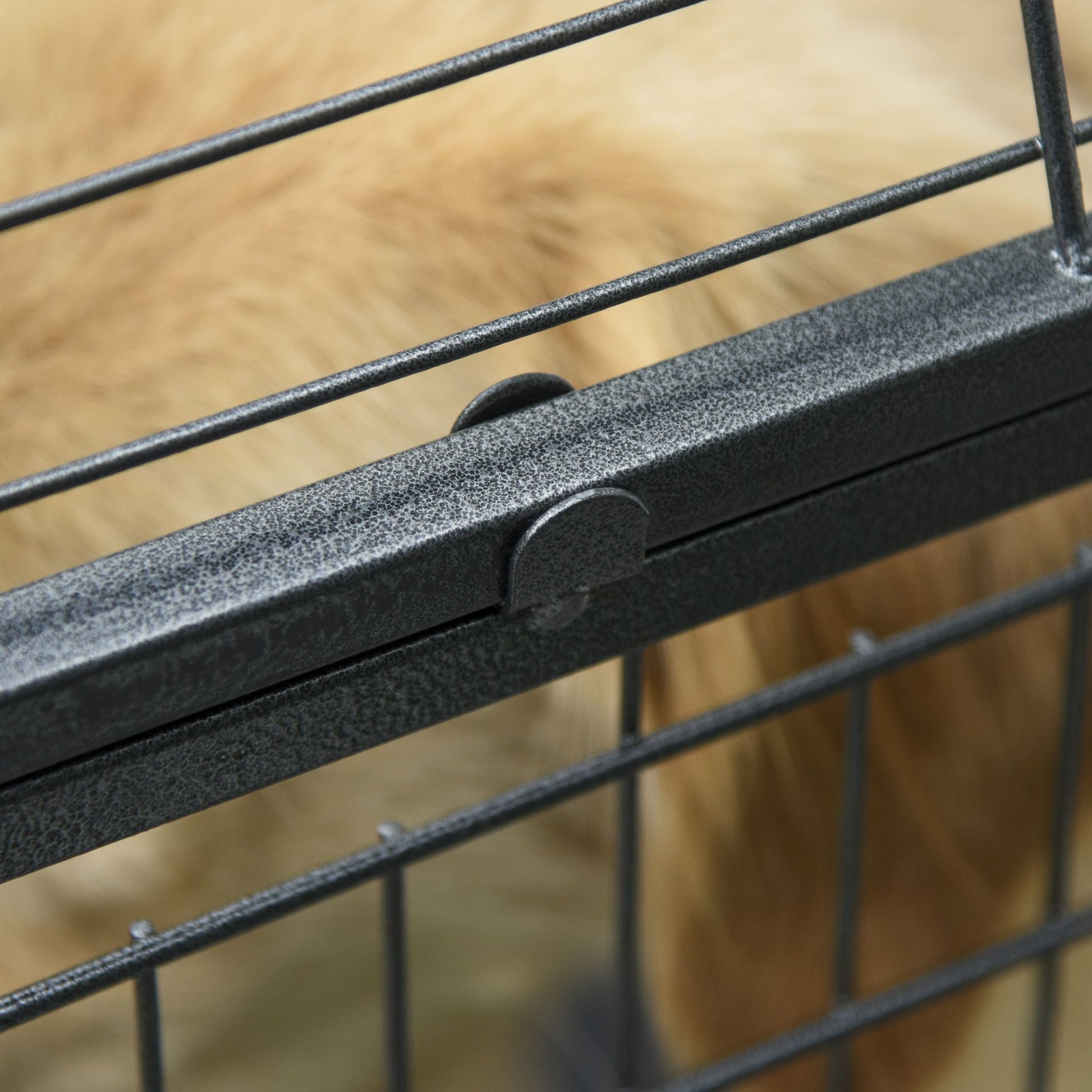 Close-up of a latch on a heavy duty dog crate with wheels showing sturdy metal construction