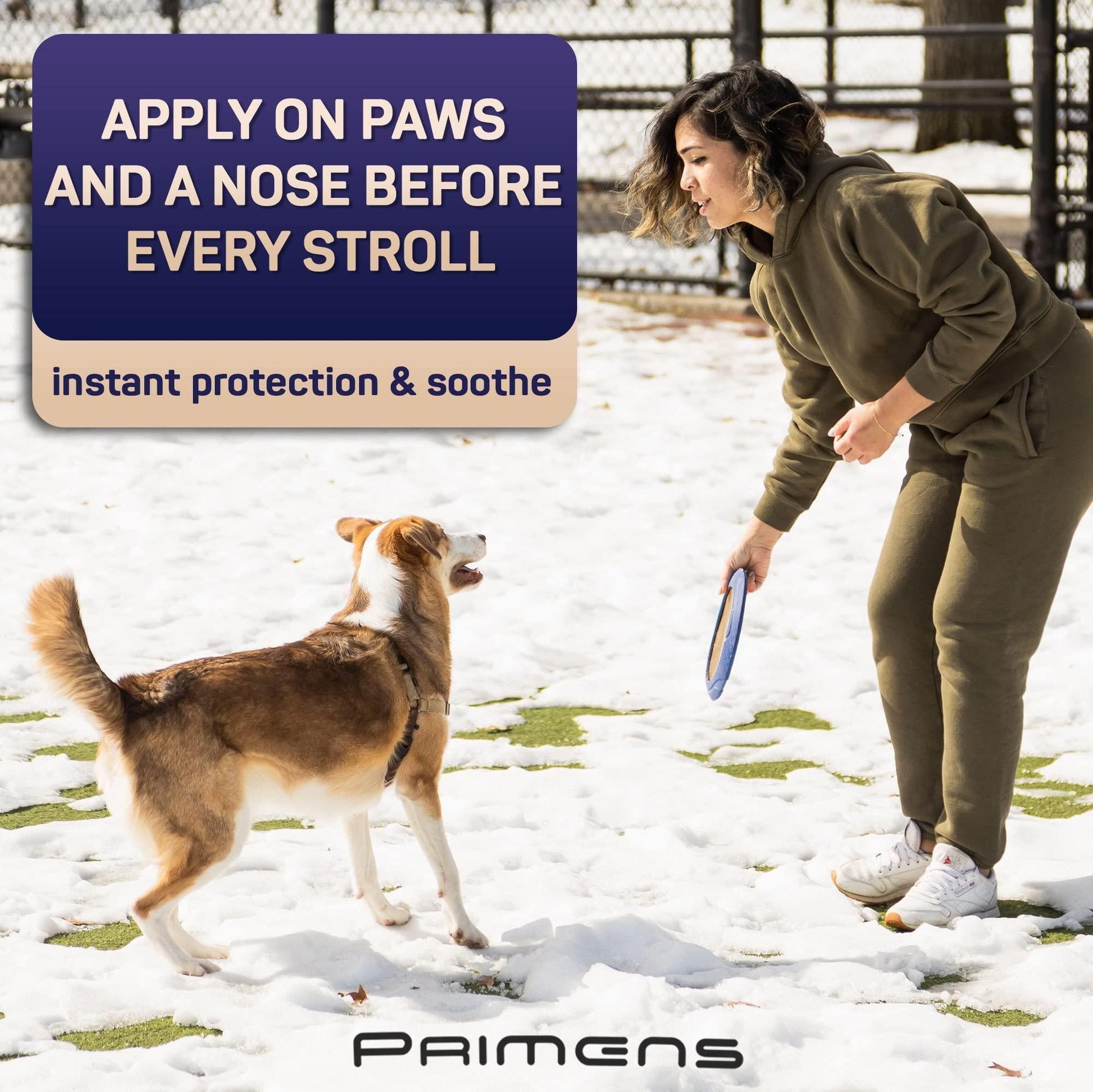Woman playing with dog in snow promoting natural dog paw balm for paw and nose protection