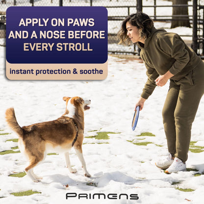 Woman playing with dog in snow promoting natural dog paw balm for paw and nose protection
