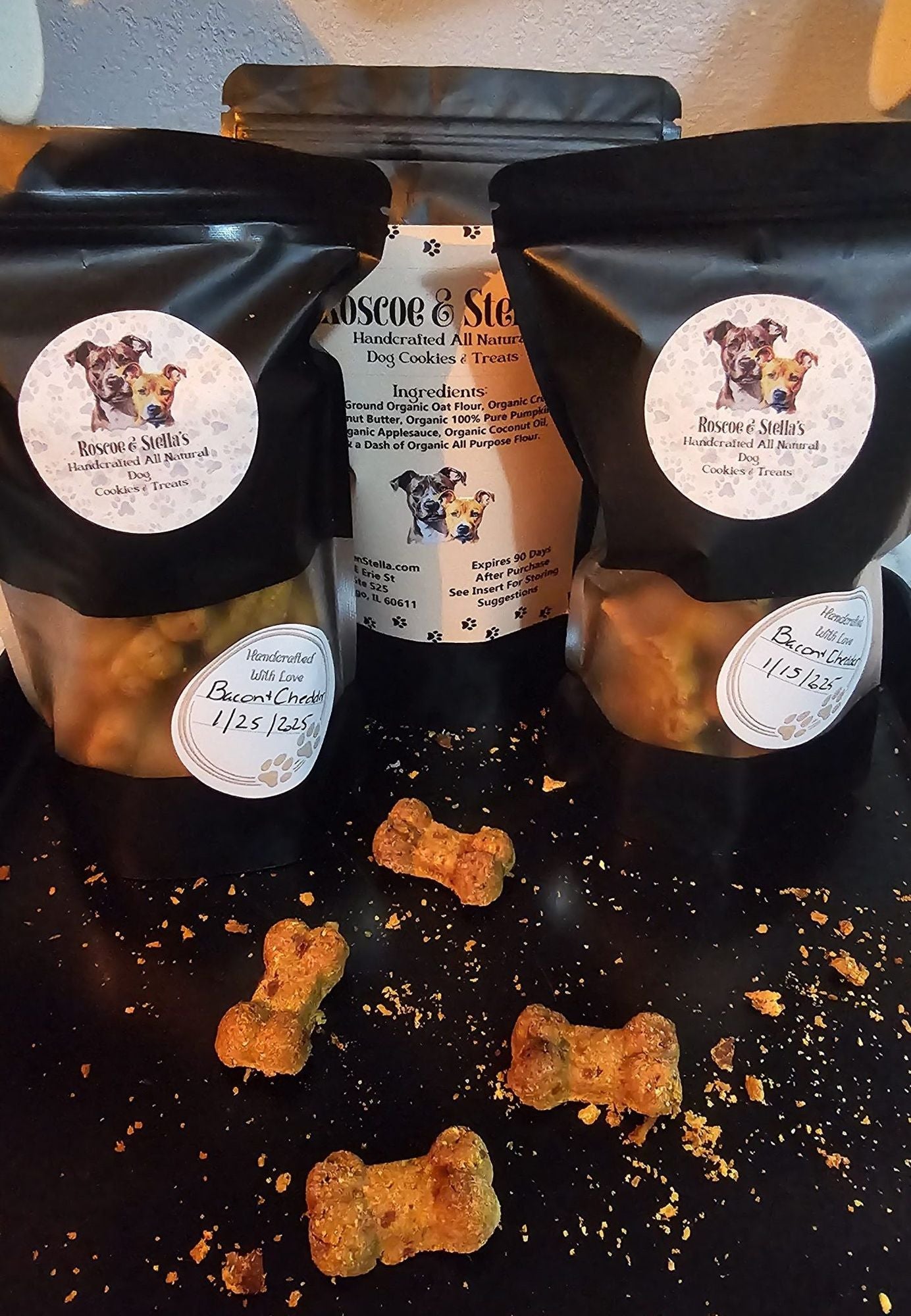 PawCounter.com natural dog treats in black resealable bags with dog bone-shaped treats on a black surface