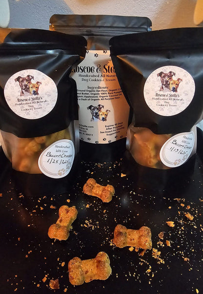 PawCounter natural dog treats in black resealable bags with bone-shaped treats scattered on a black surface